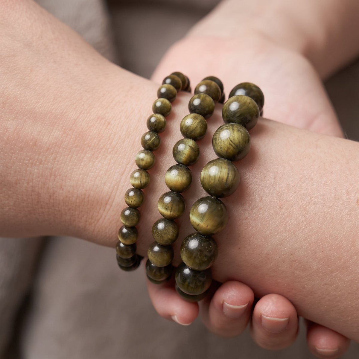 Trois bracelets en œil de chat de diamètres différents, portés ensemble au poignet - visuel provisoire
