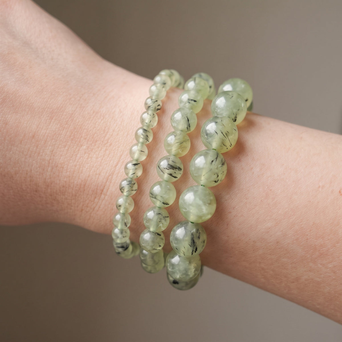 Trois bracelets en préhnite de diamètres différents, portés ensemble au poignet - visuel provisoire