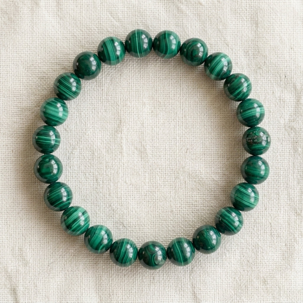 Bracelet en malachite : perles rondes de pierre naturelle de 8 mm sur elastique, sans interperle (variante temporaire), vu de dessus sur du lin ivoire - visuel provisoire