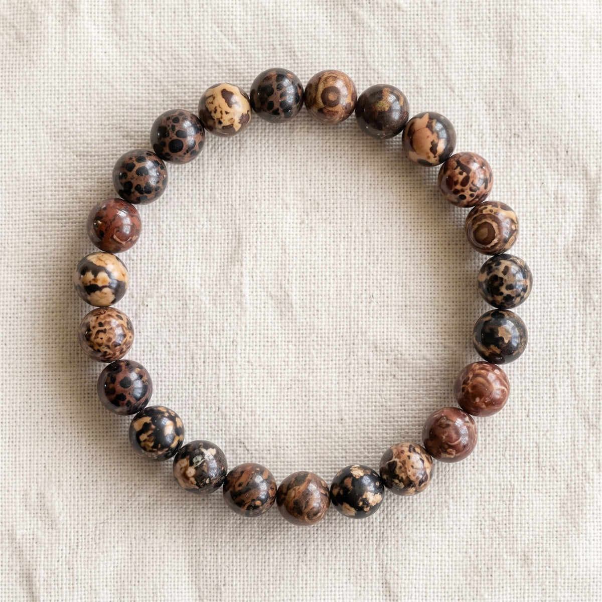 Bracelet en jaspe leopard : perles rondes de pierre naturelle de 8 mm sur elastique, sans interperle (variante temporaire), vu de dessus sur du lin ivoire - visuel provisoire