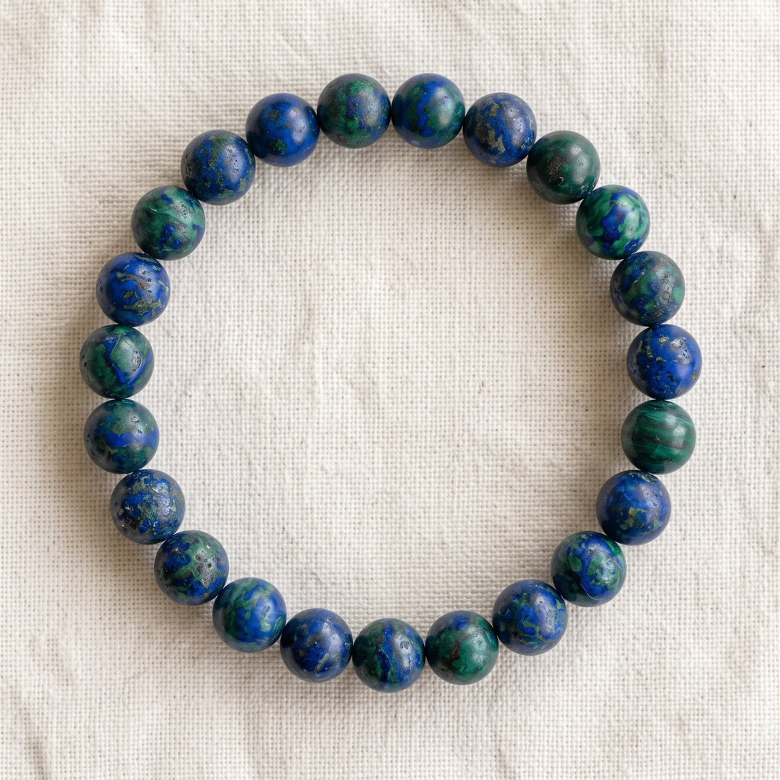 Bracelet en azurite : perles rondes de pierre naturelle de 8 mm sur elastique, sans interperle (variante temporaire), vu de dessus sur du lin ivoire - visuel provisoire