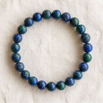 Bracelet en azurite : perles rondes de pierre naturelle de 8 mm sur elastique, sans interperle (variante temporaire), vu de dessus sur du lin ivoire - visuel provisoire