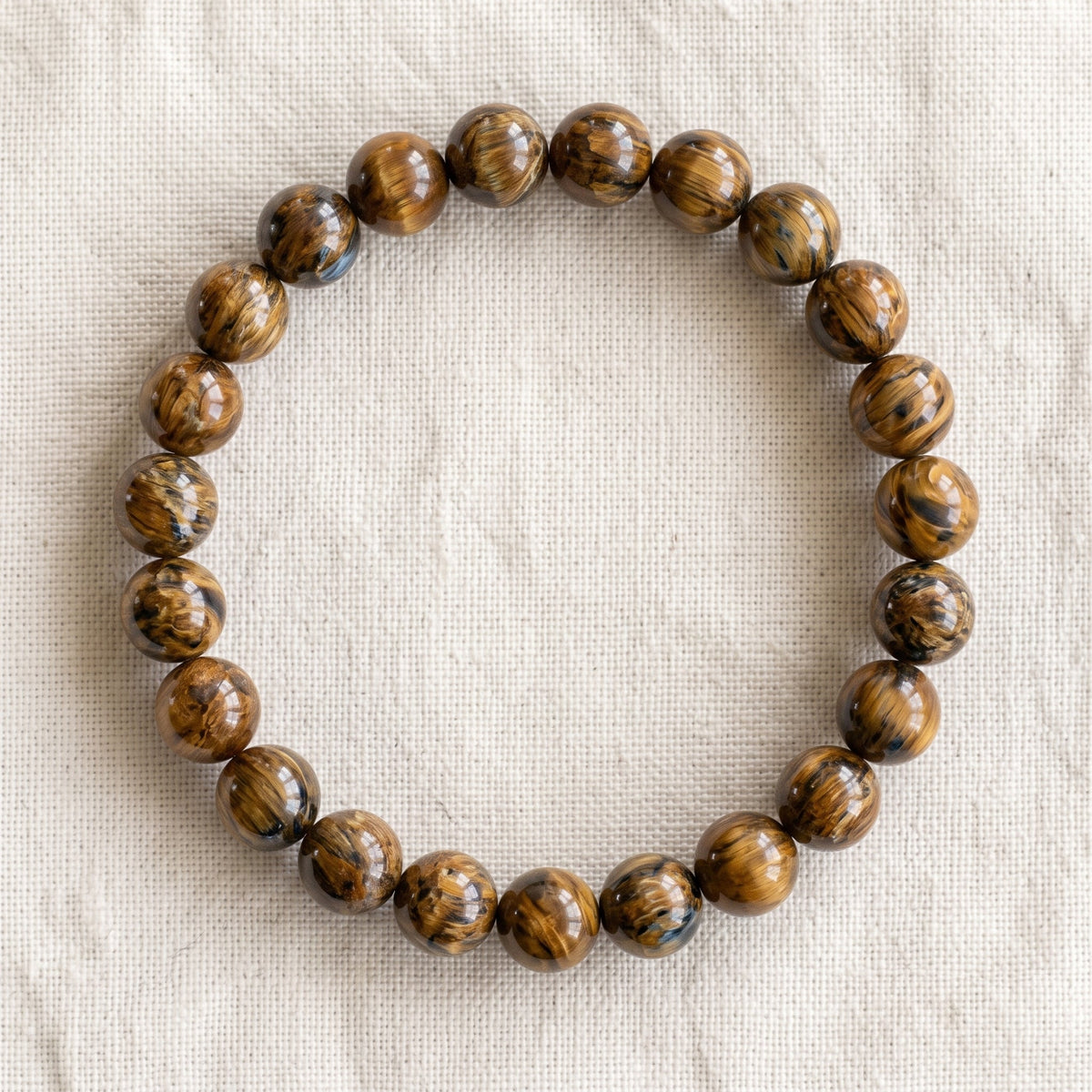 Bracelet en pietersite : perles rondes de pierre naturelle de 8 mm sur elastique, sans interperle (variante temporaire), vu de dessus sur du lin ivoire - visuel provisoire