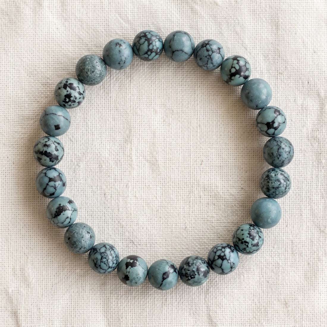Bracelet en turquoise : perles rondes de pierre naturelle de 8 mm sur elastique, sans interperle (variante temporaire), vu de dessus sur du lin ivoire - visuel provisoire