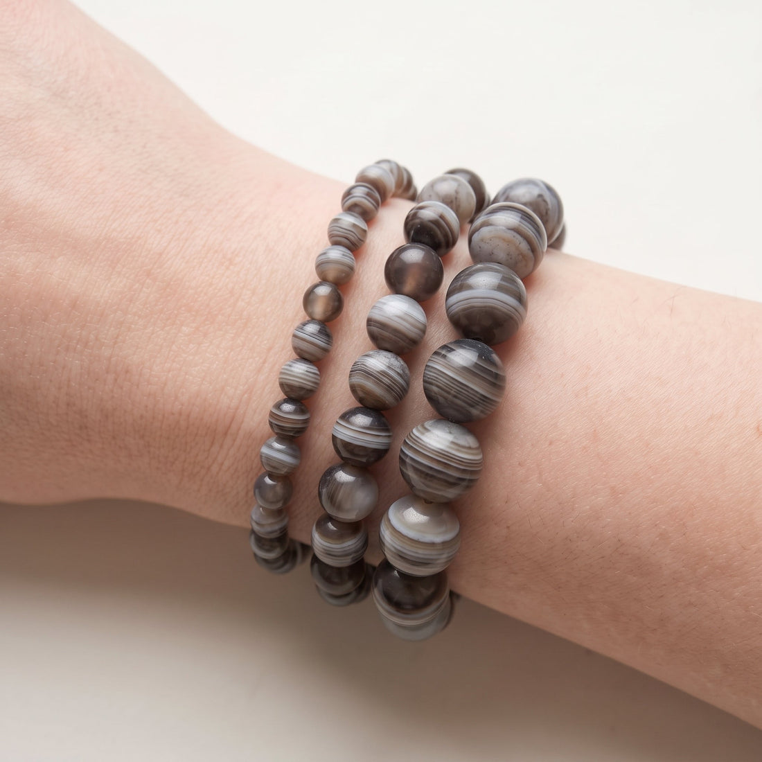 Trois bracelets en agate botswana de diamètres différents, portés ensemble au poignet - visuel provisoire