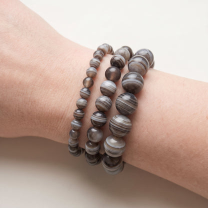Trois bracelets en agate botswana de diamètres différents, portés ensemble au poignet - visuel provisoire
