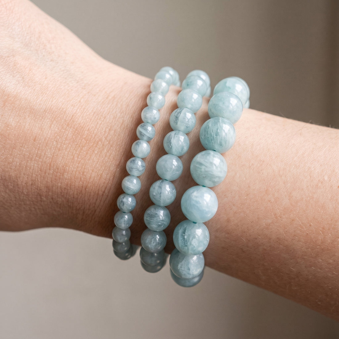 Trois bracelets en aigue marine de diamètres différents, portés ensemble au poignet - visuel provisoire