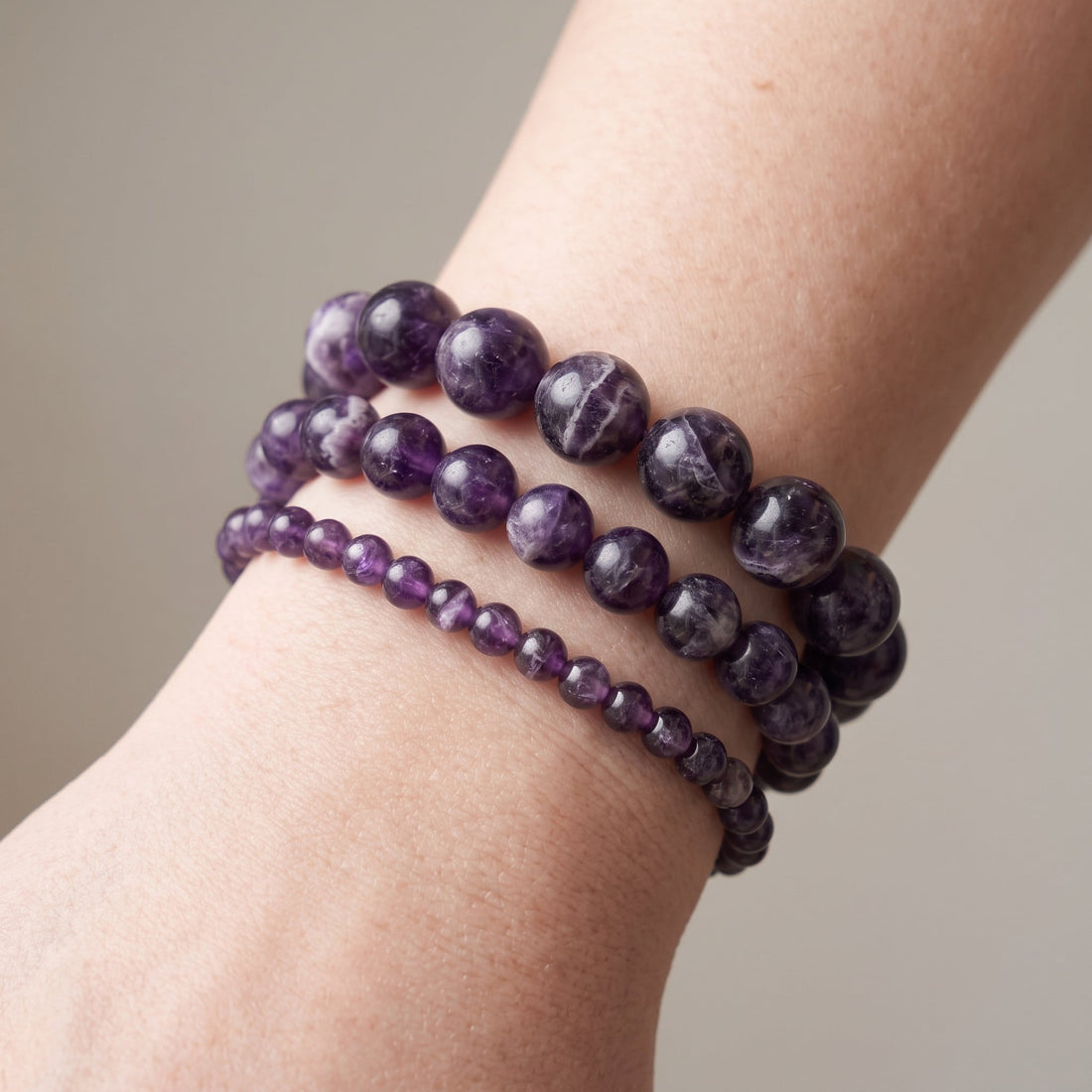 Trois bracelets en améthyste de diamètres différents, portés ensemble au poignet - visuel provisoire