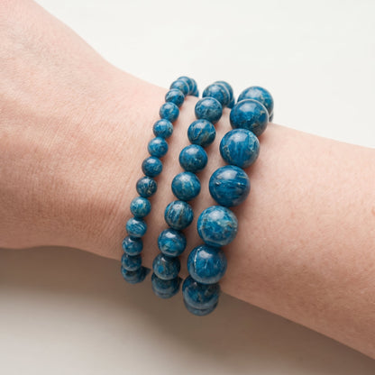 Trois bracelets en apatite bleue de diamètres différents, portés ensemble au poignet - visuel provisoire