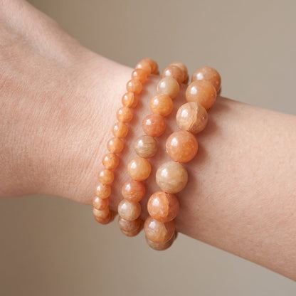 Trois bracelets en aventurine orange de diamètres différents, portés ensemble au poignet - visuel provisoire