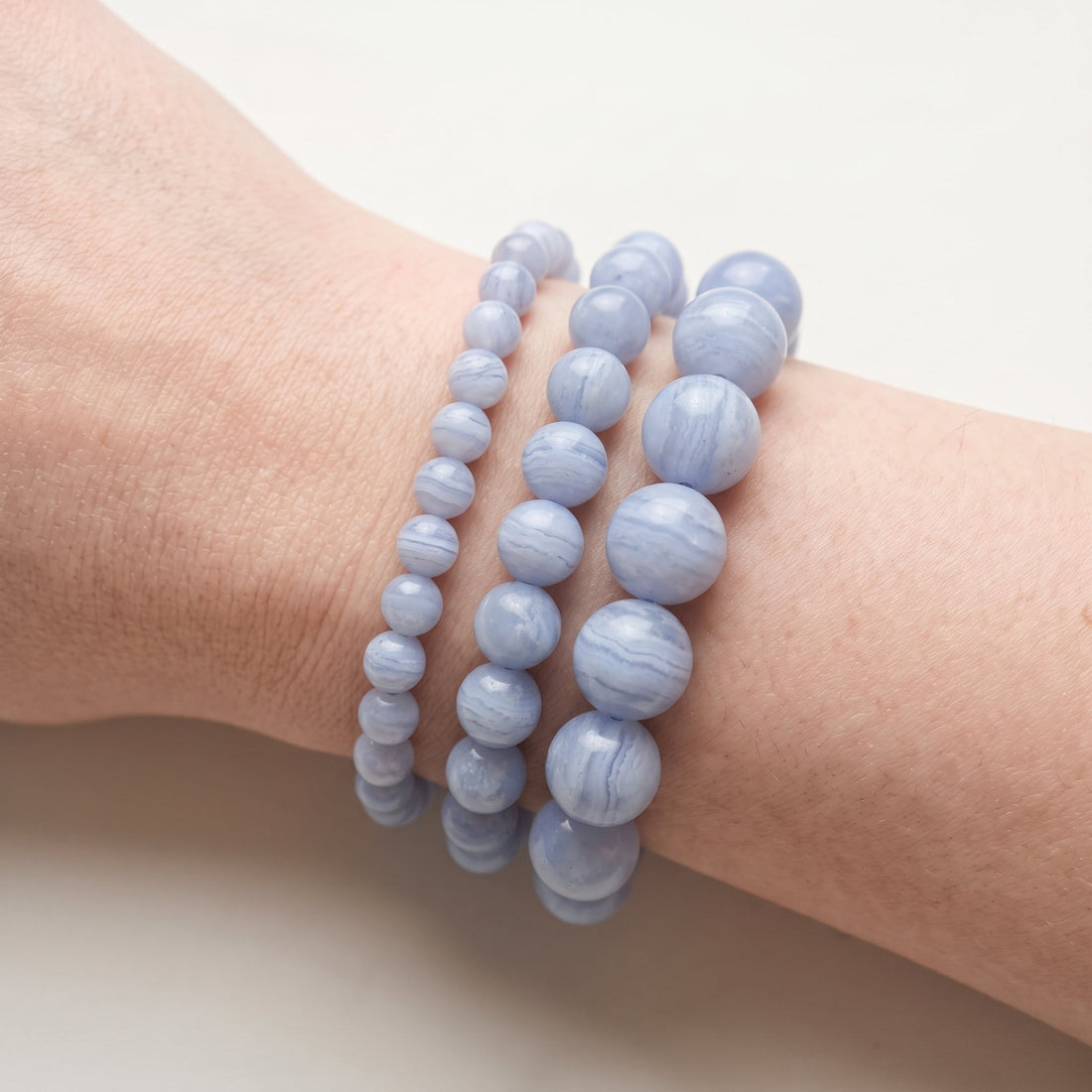 Trois bracelets en calcédoine bleue de diamètres différents, portés ensemble au poignet - visuel provisoire