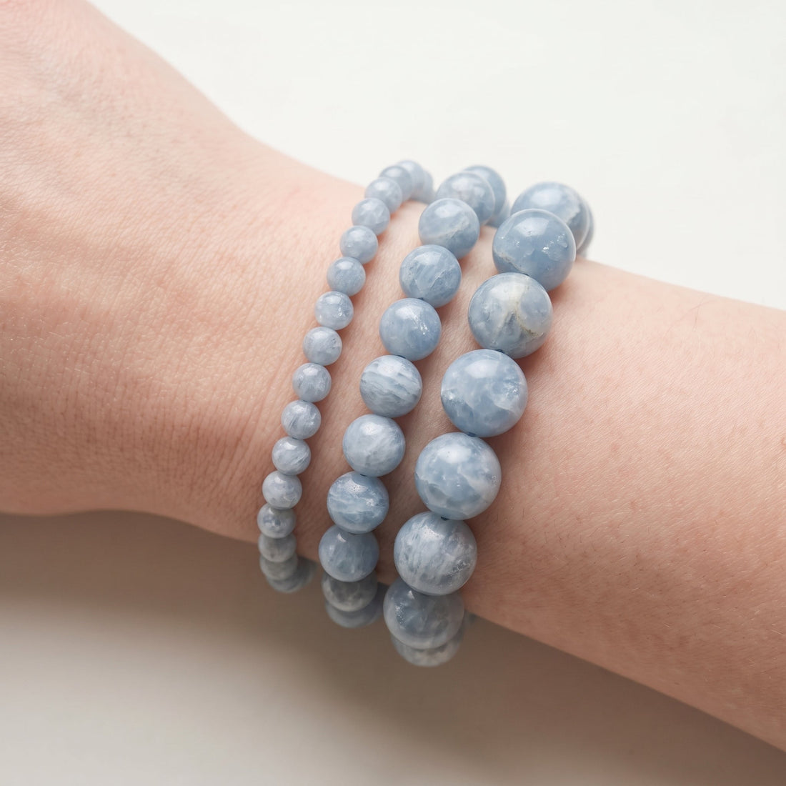 Trois bracelets en célestine de diamètres différents, portés ensemble au poignet - visuel provisoire