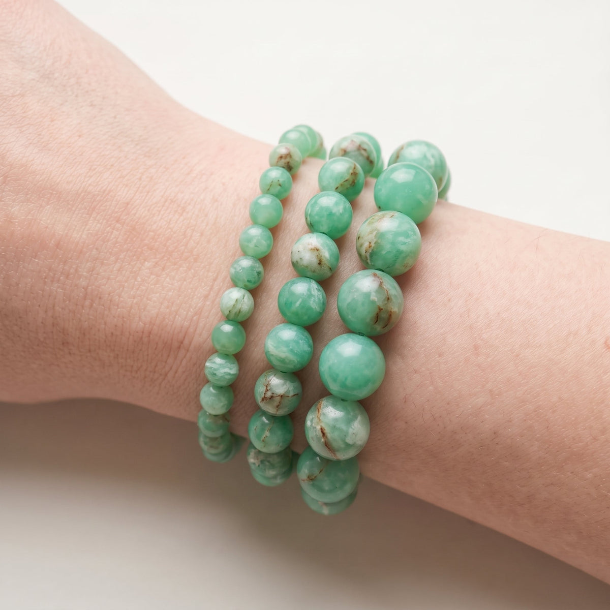 Trois bracelets en chrysoprase de diamètres différents, portés ensemble au poignet - visuel provisoire