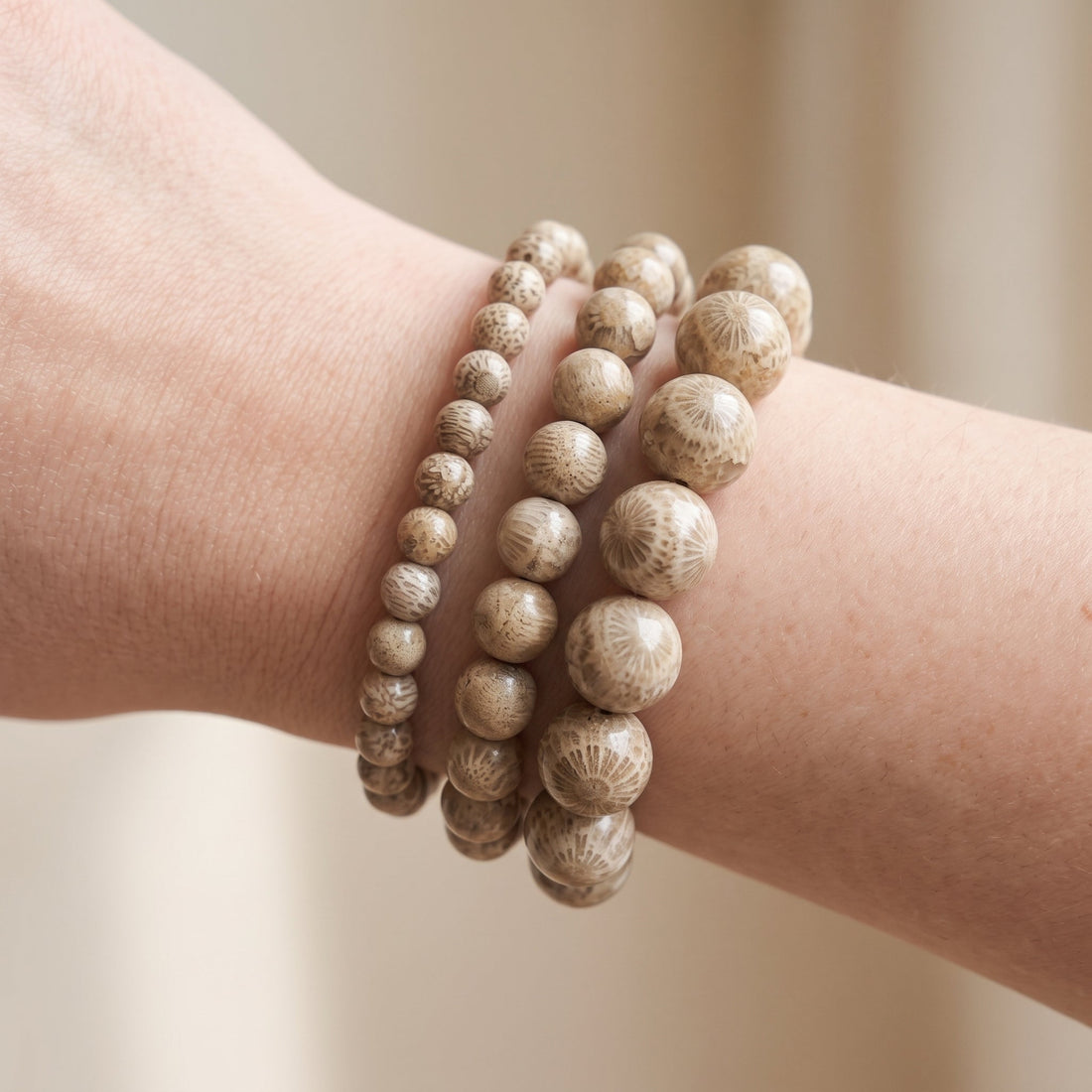 Trois bracelets en corail fossilisé de diamètres différents, portés ensemble au poignet - visuel provisoire