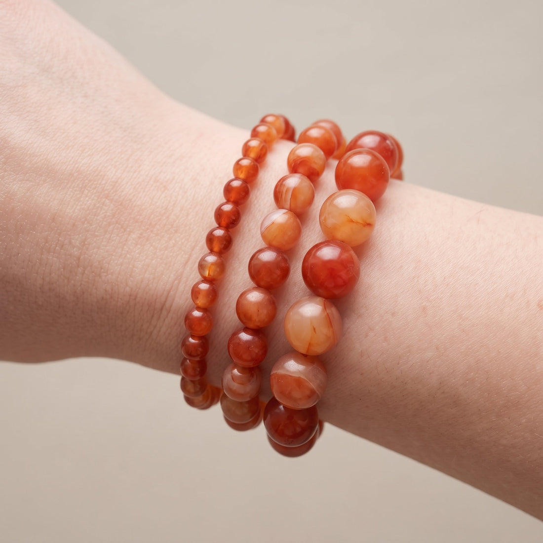 Trois bracelets en cornaline de diamètres différents, portés ensemble au poignet - visuel provisoire