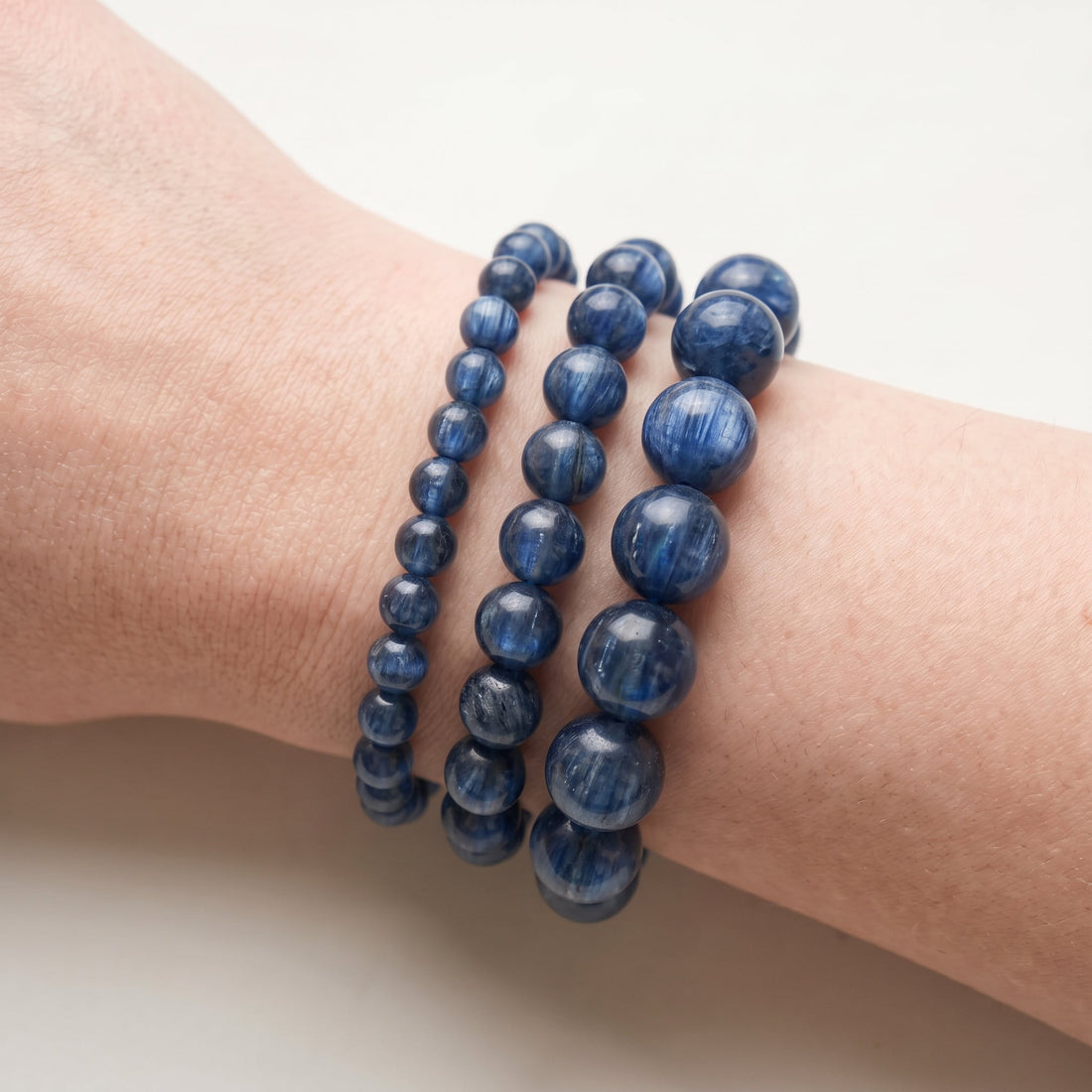 Trois bracelets en cyanite de diamètres différents, portés ensemble au poignet - visuel provisoire