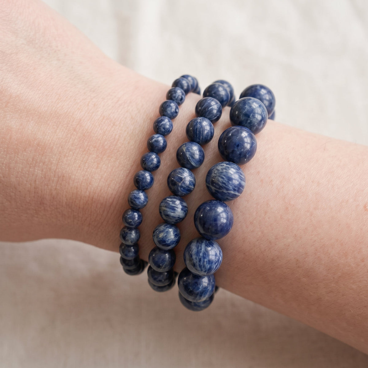 Trois bracelets en dumortiérite de diamètres différents, portés ensemble au poignet - visuel provisoire
