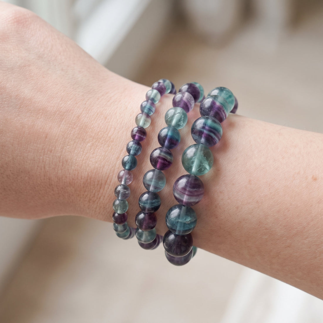 Trois bracelets en fluorite de diamètres différents, portés ensemble au poignet - visuel provisoire