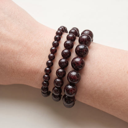 Trois bracelets en grenat de diamètres différents, portés ensemble au poignet - visuel provisoire