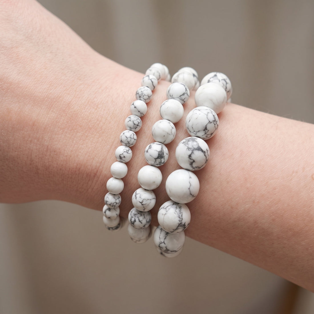 Trois bracelets en howlite de diamètres différents, portés ensemble au poignet - visuel provisoire