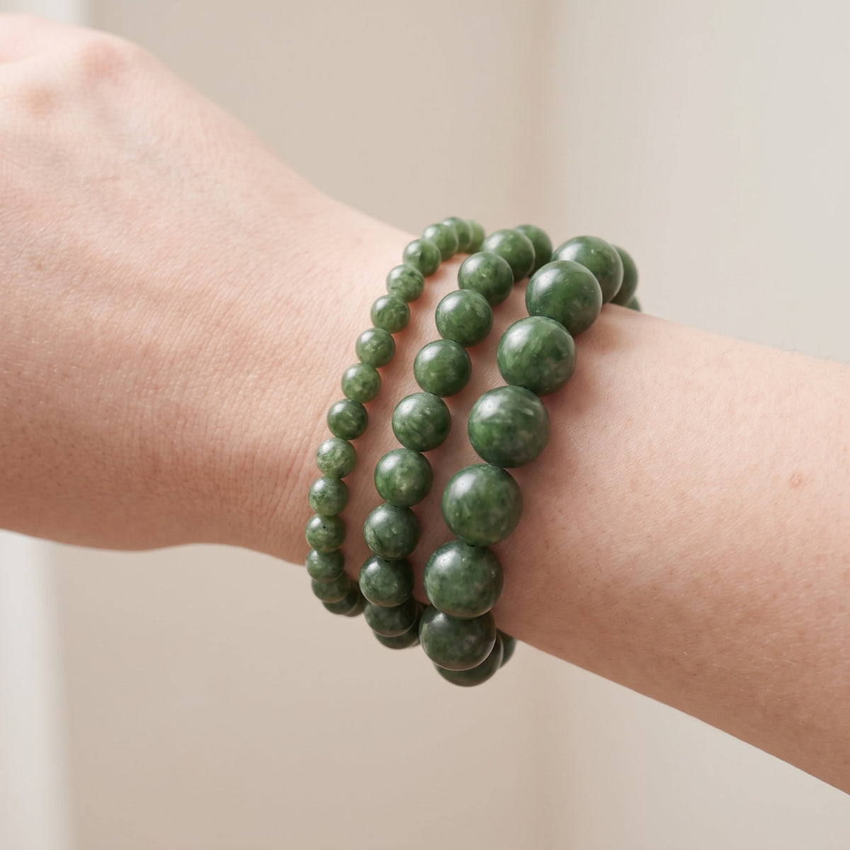 Trois bracelets en jade néphrite de diamètres différents, portés ensemble au poignet - visuel provisoire