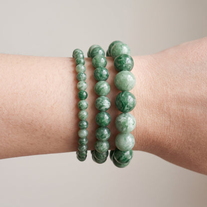 Trois bracelets en jade verte de diamètres différents, portés ensemble au poignet - visuel provisoire