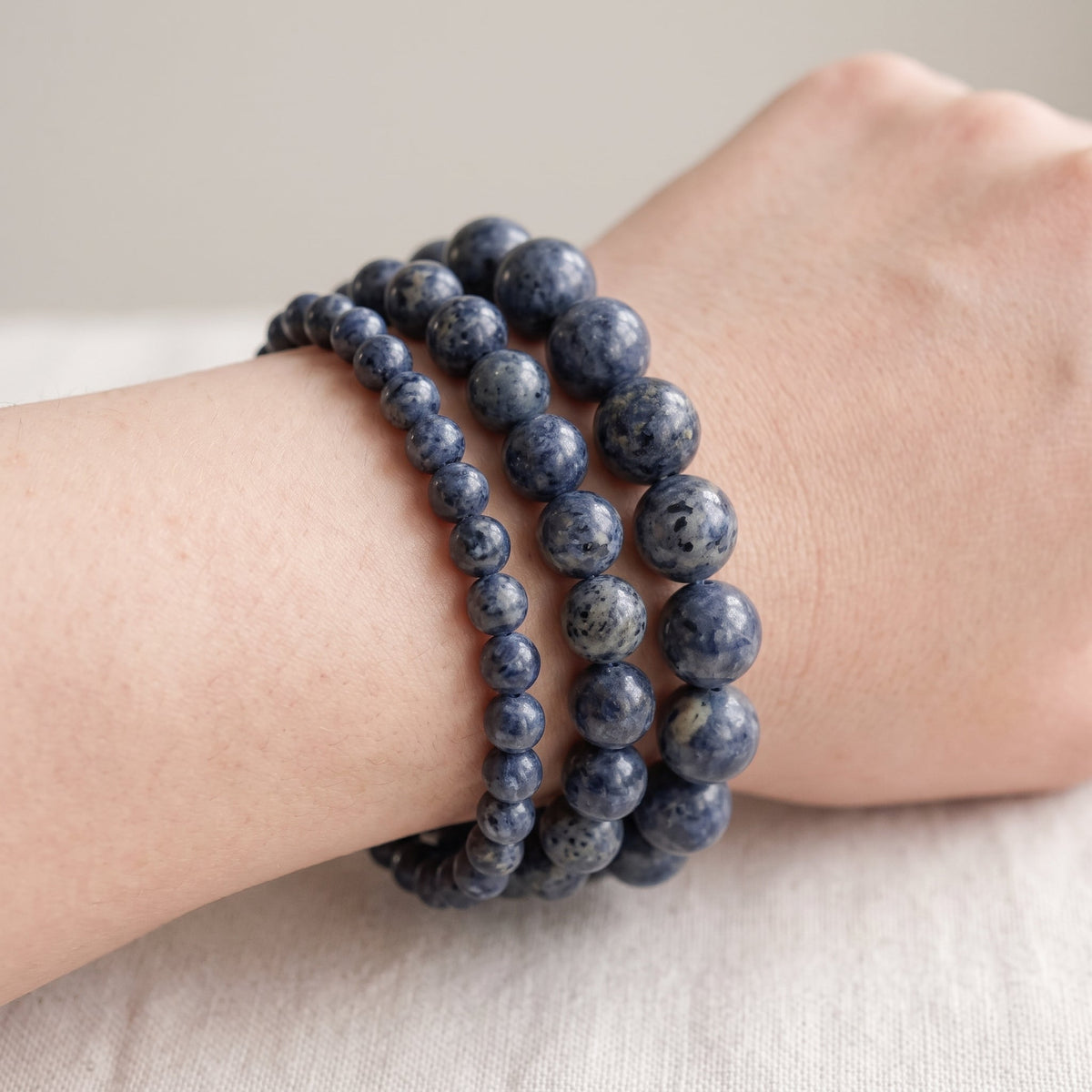 Trois bracelets en jaspe bleu de diamètres différents, portés ensemble au poignet - visuel provisoire