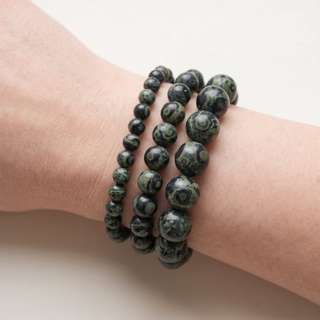 Trois bracelets en jaspe kambaba de diamètres différents, portés ensemble au poignet - visuel provisoire