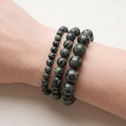 Trois bracelets en jaspe kambaba de diamètres différents, portés ensemble au poignet - visuel provisoire
