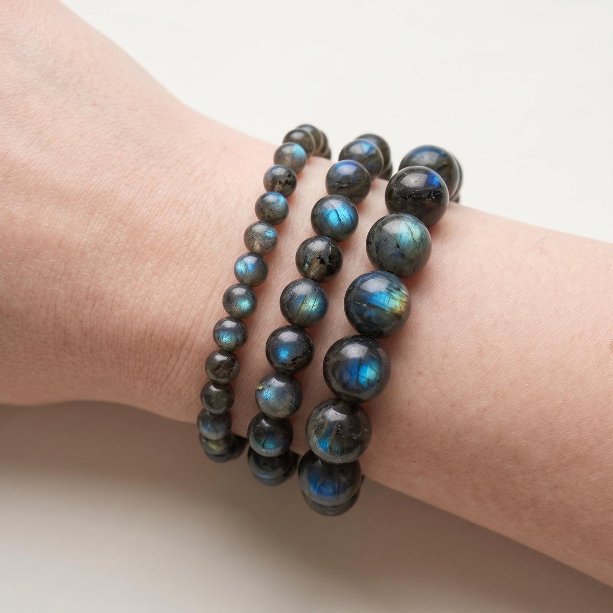 Trois bracelets en labradorite de diamètres différents, portés ensemble au poignet - visuel provisoire