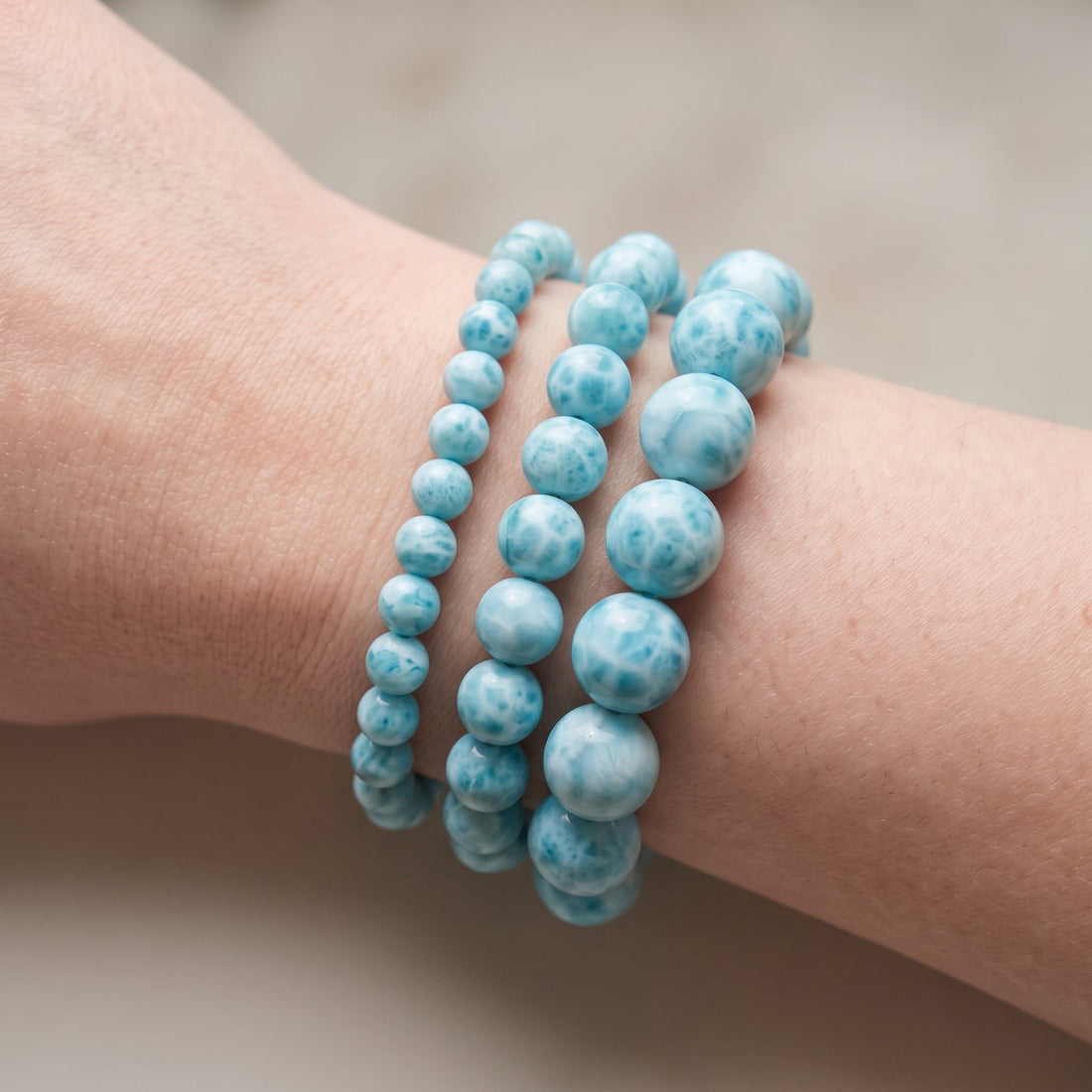 Trois bracelets en larimar de diamètres différents, portés ensemble au poignet - visuel provisoire