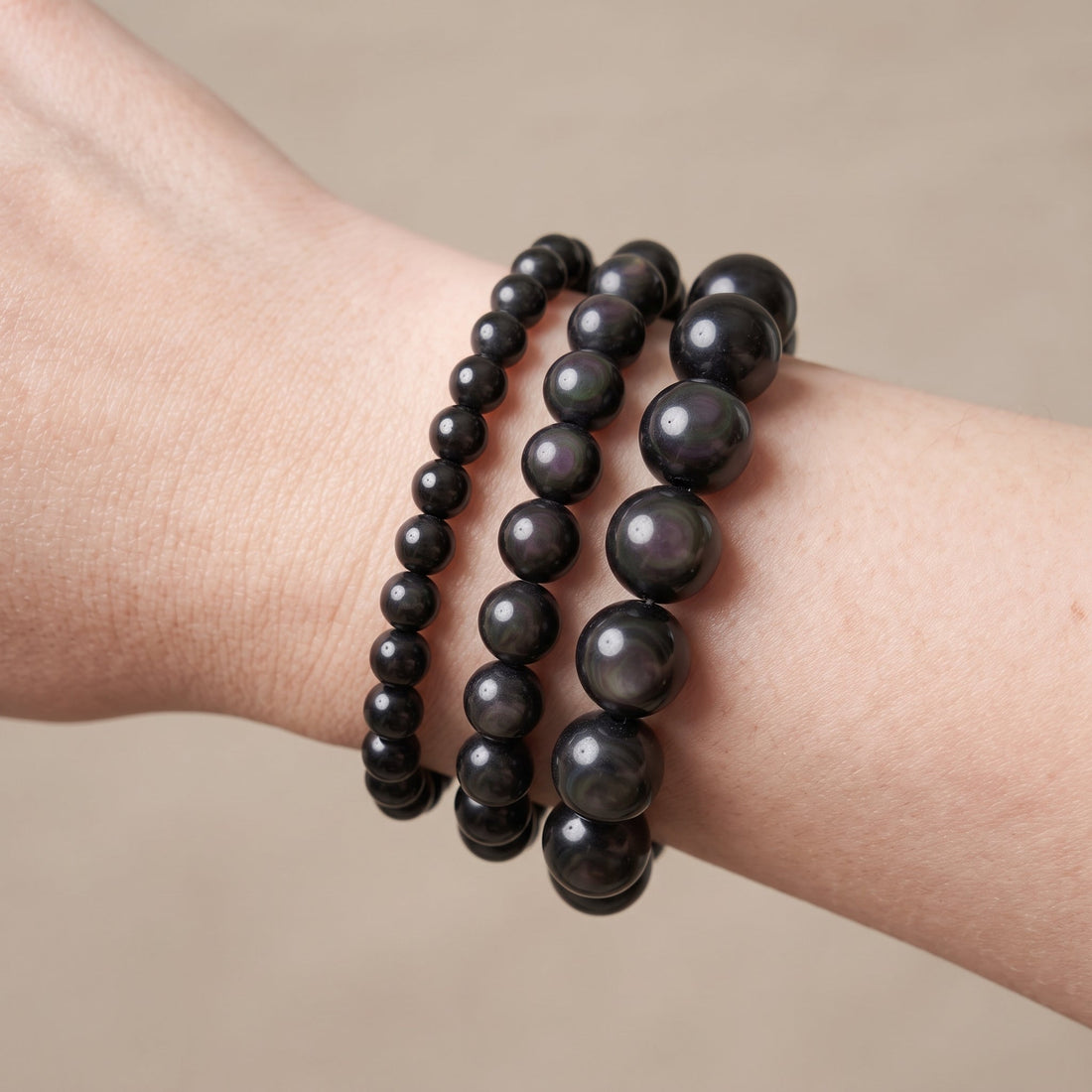 Trois bracelets en obsidienne œil céleste de diamètres différents, portés ensemble au poignet - visuel provisoire