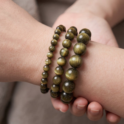 Trois bracelets en œil de chat de diamètres différents, portés ensemble au poignet - visuel provisoire