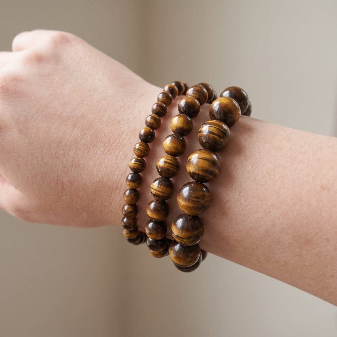 Trois bracelets en œil de tigre de diamètres différents, portés ensemble au poignet - visuel provisoire