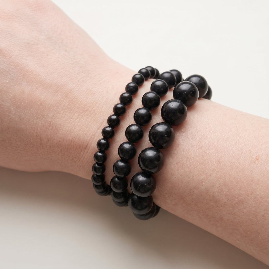 Trois bracelets en onyx de diamètres différents, portés ensemble au poignet - visuel provisoire