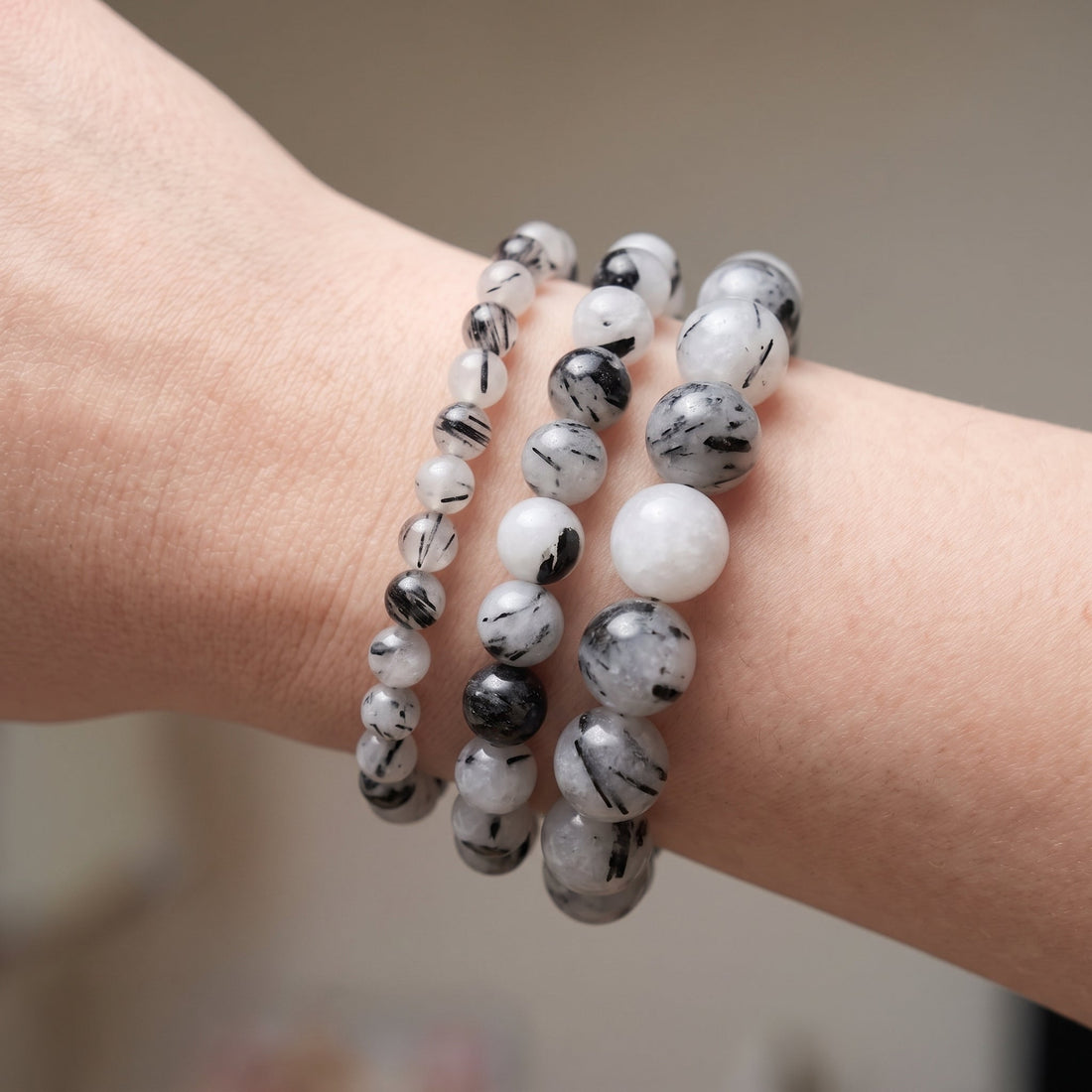 Trois bracelets en quartz tourmaline de diamètres différents, portés ensemble au poignet - visuel provisoire