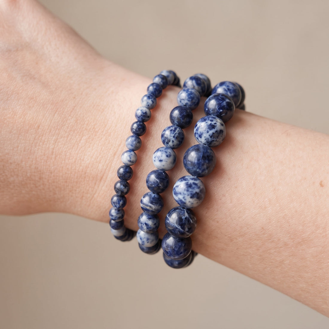 Trois bracelets en sodalite de diamètres différents, portés ensemble au poignet - visuel provisoire