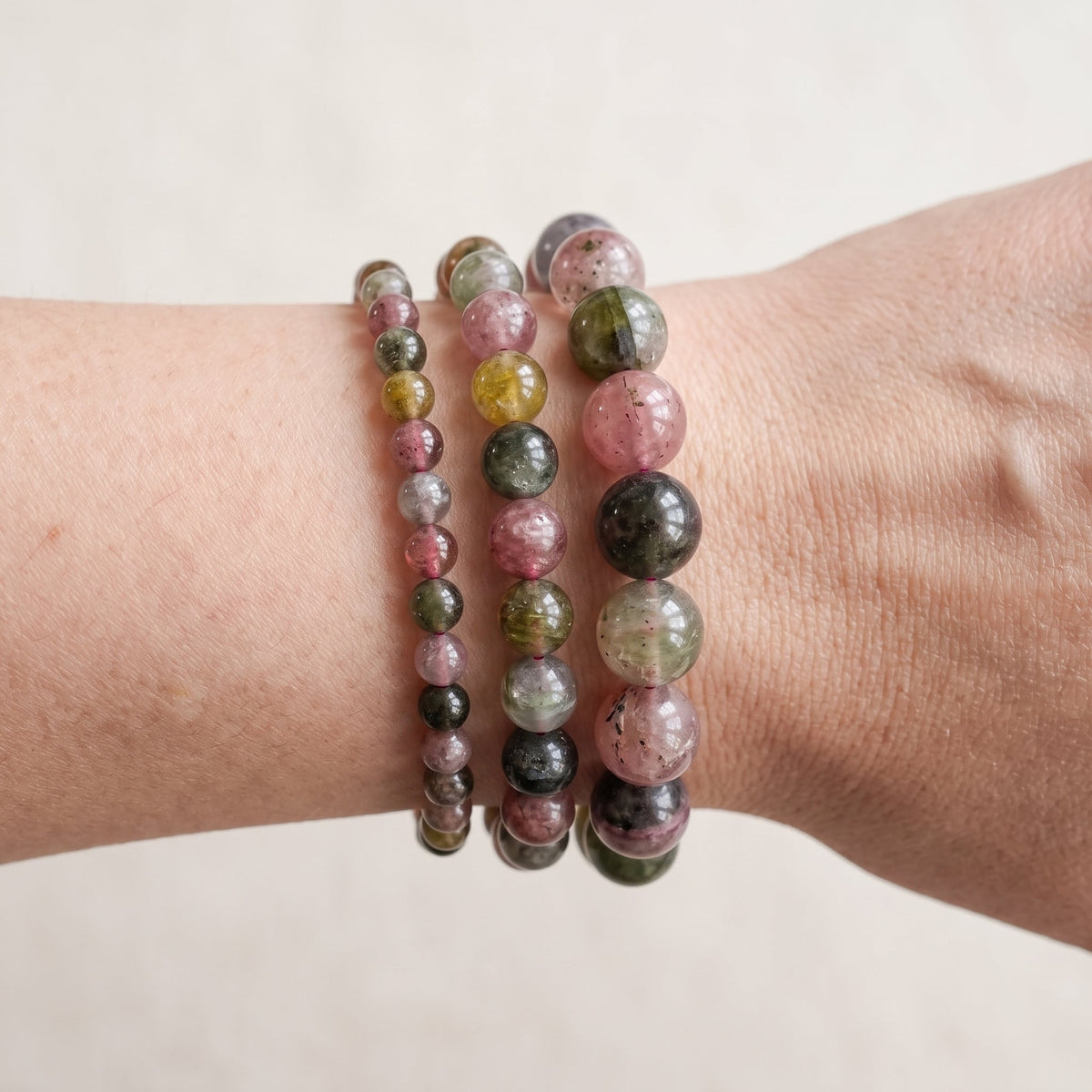 Trois bracelets en tourmaline multicolore de diamètres différents, portés ensemble au poignet - visuel provisoire