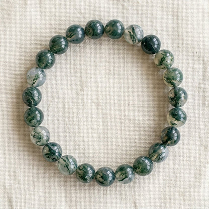 Bracelet en agate mousse : perles rondes de pierre naturelle de 8 mm sur elastique, sans interperle (variante temporaire), vu de dessus sur du lin ivoire - visuel provisoire