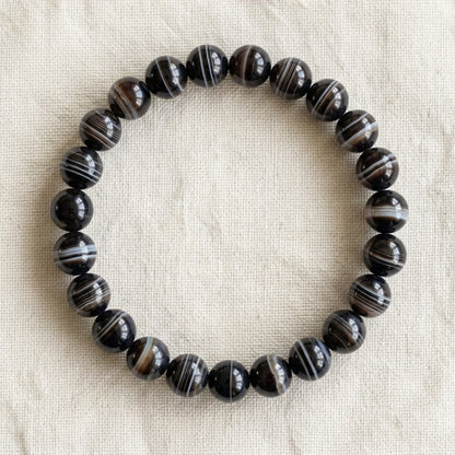 Bracelet en agate sardonyx : perles rondes de pierre naturelle de 8 mm sur elastique, sans interperle (variante temporaire), vu de dessus sur du lin ivoire - visuel provisoire