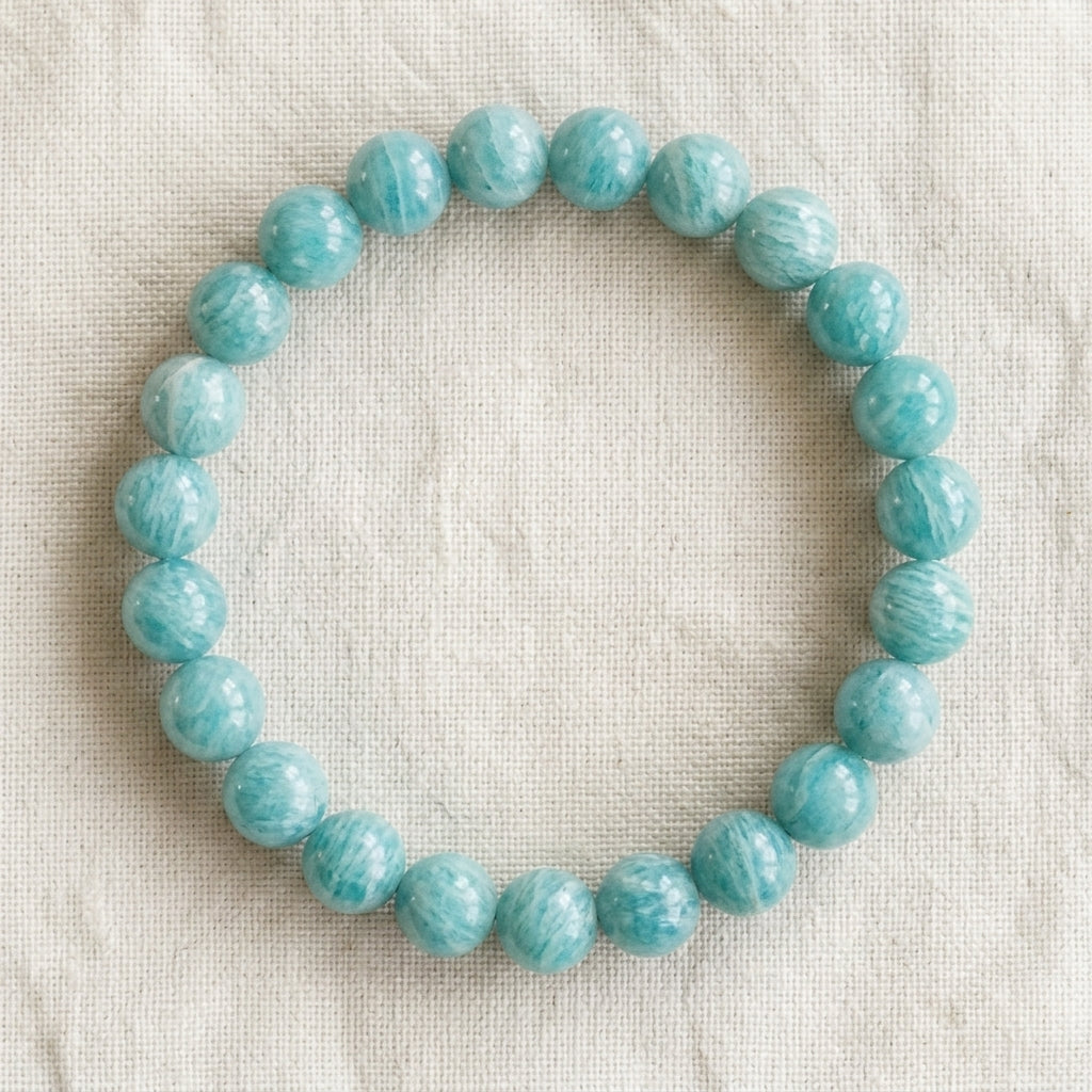 Bracelet en amazonite : perles rondes de pierre naturelle de 8 mm sur elastique, sans interperle (variante temporaire), vu de dessus sur du lin ivoire - visuel provisoire