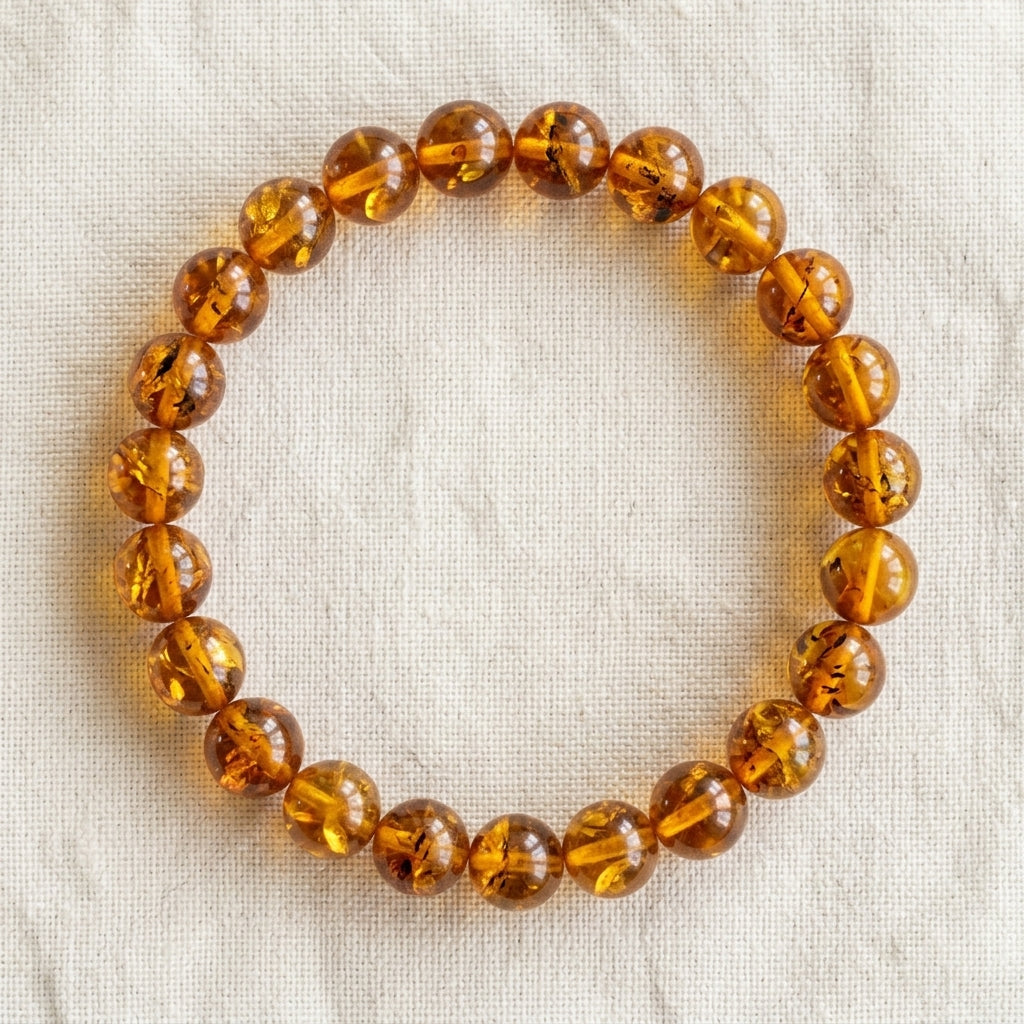 Bracelet en ambre : perles rondes de pierre naturelle de 8 mm sur elastique, sans interperle (variante temporaire), vu de dessus sur du lin ivoire - visuel provisoire