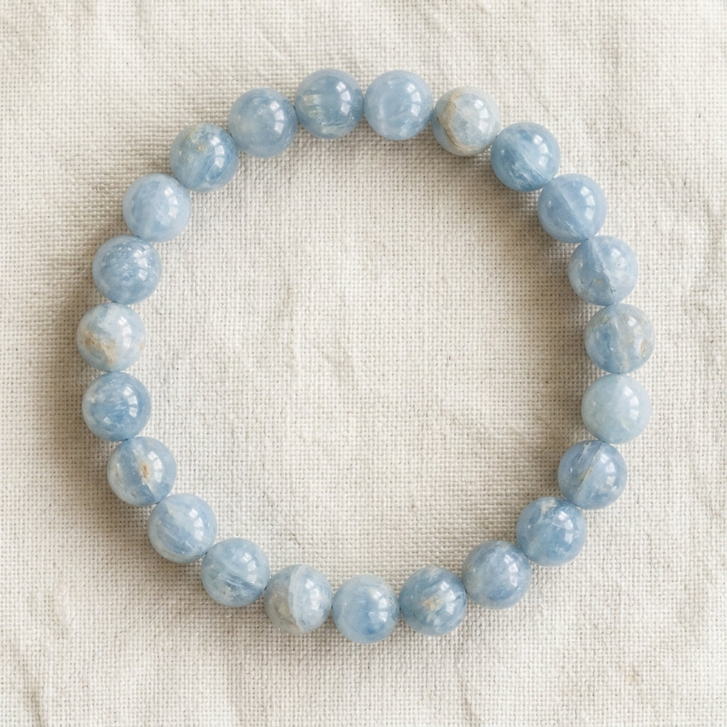 Bracelet en célestine : perles rondes de pierre naturelle de 8 mm sur elastique, sans interperle (variante temporaire), vu de dessus sur du lin ivoire - visuel provisoire