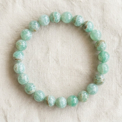 Bracelet en chrysoprase : perles rondes de pierre naturelle de 8 mm sur elastique, sans interperle (variante temporaire), vu de dessus sur du lin ivoire - visuel provisoire