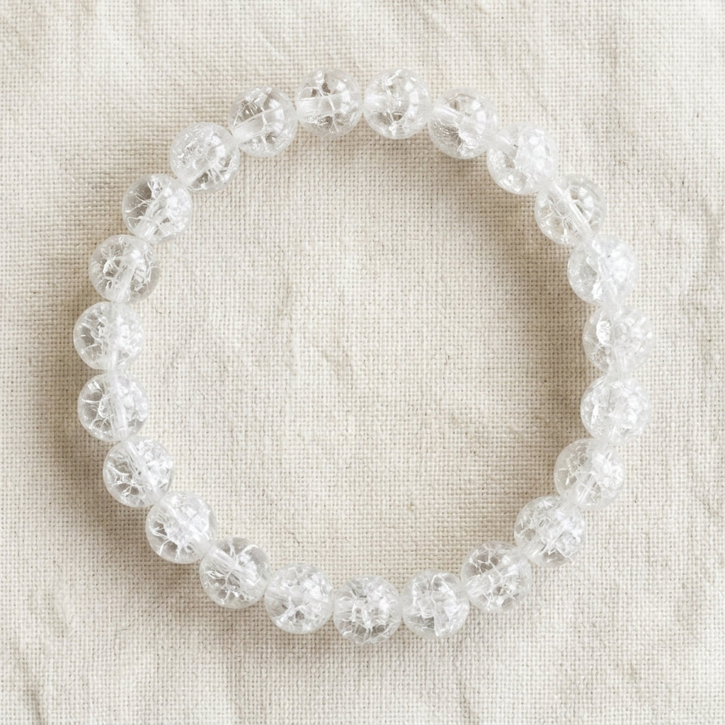 Bracelet en cristal de roche : perles rondes de pierre naturelle de 8 mm sur elastique, sans interperle (variante temporaire), vu de dessus sur du lin ivoire - visuel provisoire