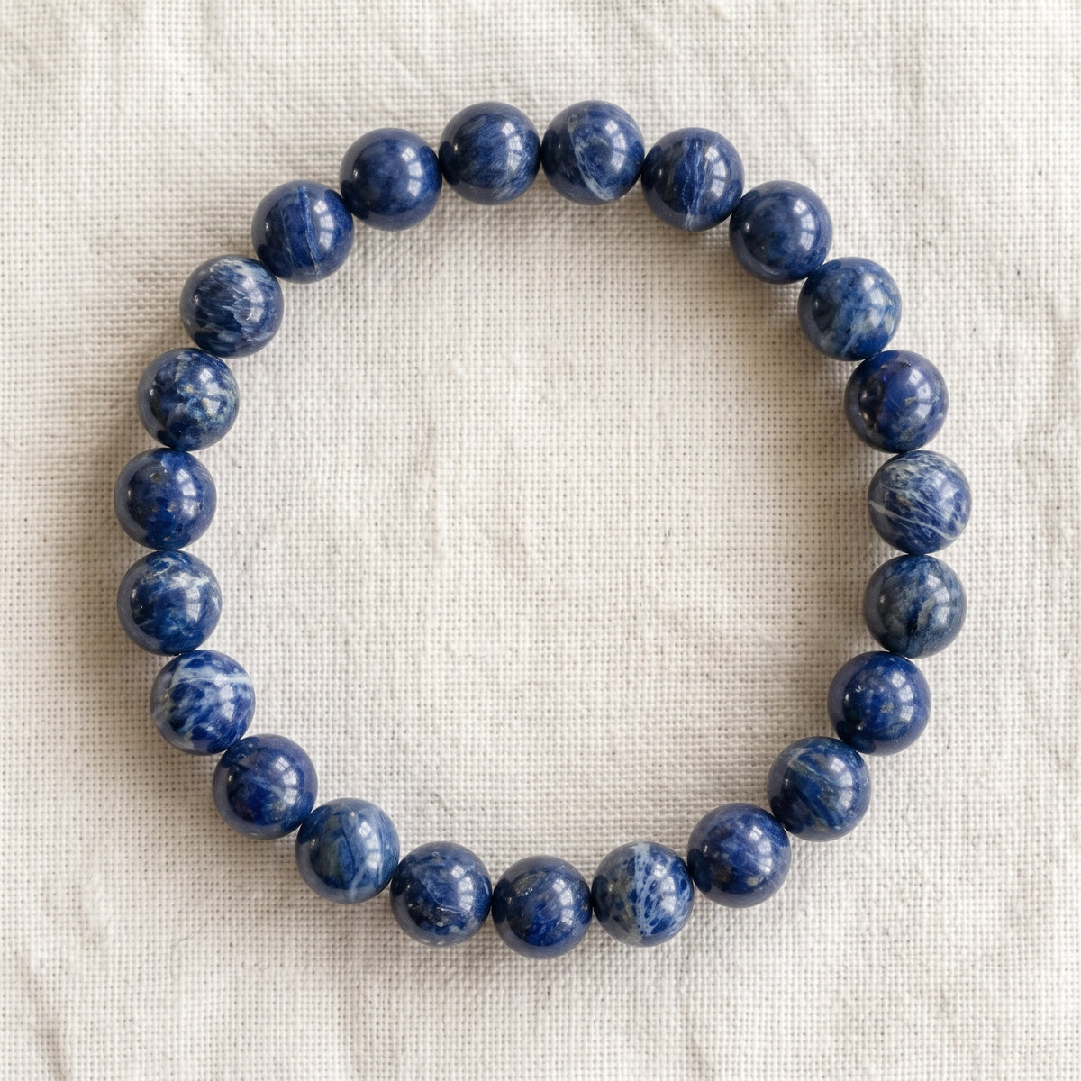 Bracelet en dumortiérite : perles rondes de pierre naturelle de 8 mm sur elastique, sans interperle (variante temporaire), vu de dessus sur du lin ivoire - visuel provisoire