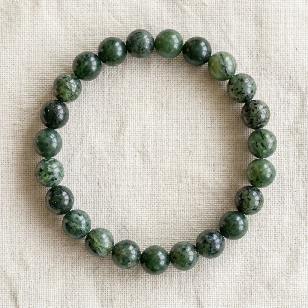 Bracelet en jade néphrite : perles rondes de pierre naturelle de 8 mm sur elastique, sans interperle (variante temporaire), vu de dessus sur du lin ivoire - visuel provisoire
