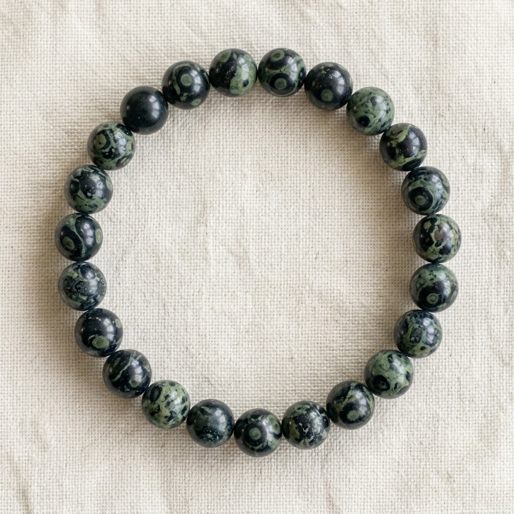 Bracelet en jaspe kambaba : perles rondes de pierre naturelle de 8 mm sur elastique, sans interperle (variante temporaire), vu de dessus sur du lin ivoire - visuel provisoire
