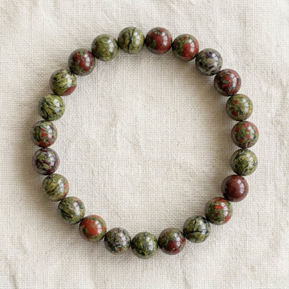Bracelet en jaspe sang de dragon : perles rondes de pierre naturelle de 8 mm sur elastique, sans interperle (variante temporaire), vu de dessus sur du lin ivoire - visuel provisoire