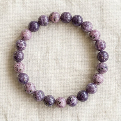 Bracelet en lépidolite : perles rondes de pierre naturelle de 8 mm sur elastique, sans interperle (variante temporaire), vu de dessus sur du lin ivoire - visuel provisoire